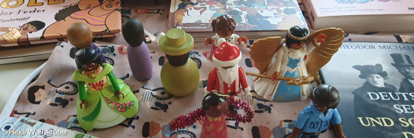 Büchertisch und vielfarbige Playmobilfiguren
