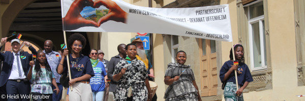 Menschen aus Tansania mit Partnerschaftsplakat