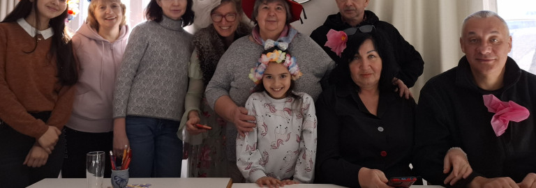 Gruppe von Menschen hinter einem Tisch mit Blüten im Haar