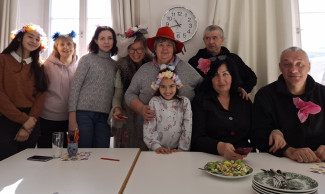 Gruppe von Menschen hinter einem Tisch mit Blüten im Haar