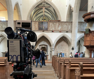 Fernsehkamera vor Kirchenaltarwand