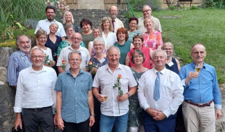 Gruppenbild mit Männer und  Frauen mit Rosen und Sektgläsern in der Hand